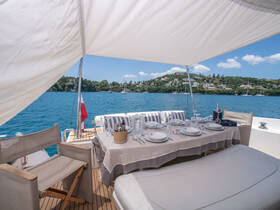 A beautifully set dining area on a yacht, featuring elegant tableware and a stunning view of the water — perfect for enjoying meals while cruising.