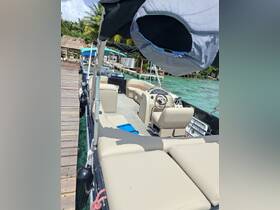 Interior view of a spacious pontoon boat featuring comfortable seating and a well-equipped helm, perfect for relaxing on the water.