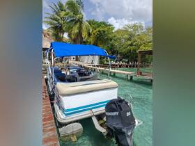 A well-equipped pontoon boat docked in clear waters, showcasing its spacious seating and stylish canopy, perfect for leisurely outings.