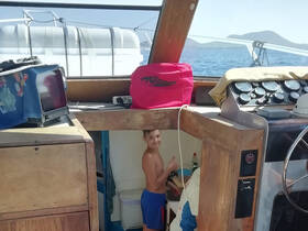 A young boy enjoys a moment inside the boat's cabin, showcasing the helm and interior space — perfect for family adventures on the water.