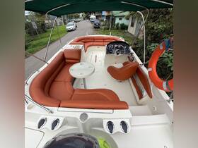 An inviting interior view of a boat featuring comfortable seating and a helm, perfect for relaxing and enjoying time on the water.