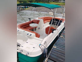 A well-appointed interior view of a boat featuring comfortable seating and a helm, perfect for relaxing on the water.