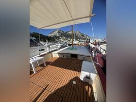 Interior view of a boat's deck featuring wooden flooring and a shaded area, ideal for relaxation and enjoying the surrounding scenery.