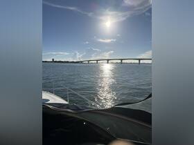 A serene view of a boat's bow with a picturesque bridge in the background, reflecting sunlight on the water — perfect for showcasing scenic boating experiences.