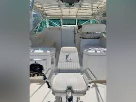 Inside view of the helm area of a boat, featuring comfortable seating and a well-equipped console, perfect for a day on the water.