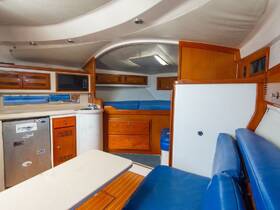 Interior view of a boat cabin featuring a well-equipped kitchen area and comfortable seating, perfect for relaxing during a day on the water.