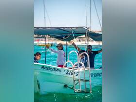 A lively crew aboard a glass-bottom boat welcomes guests, showcasing the fun and excitement of water excursions in vibrant turquoise waters.