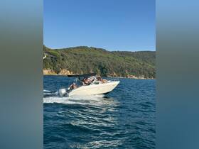 A lively group enjoys a thrilling ride on a speedboat, cutting through the waves against a stunning coastal backdrop — perfect for adventure seekers on the water.