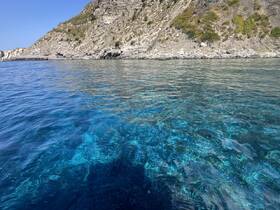 A stunning view of crystal-clear waters and rocky coastline, perfect for showcasing the natural beauty of the area.
