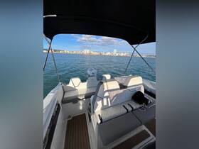 Interior view of a modern boat showcasing comfortable seating and helm area, perfect for a day out on the water.