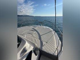 A serene view of the front deck of a boat, showcasing its sleek design against a backdrop of calm waters and distant mountains — perfect for leisurely outings on the water.