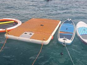 A collection of water amenities including a floating mat and paddleboards, perfect for fun and relaxation on the water.