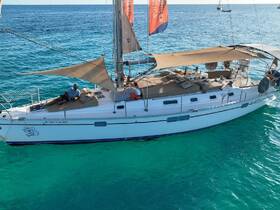 Aerial view of a sailboat anchored in clear turquoise waters, showcasing its spacious deck and relaxing atmosphere.
