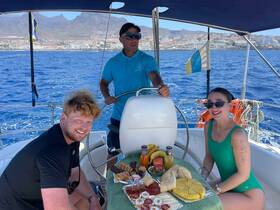 A cheerful group enjoys a delightful spread of snacks aboard a boat, perfect for a fun day on the water with friends.