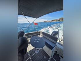 A well-appointed interior view of a boat's seating area and helm, showcasing a sleek design and comfortable space for passengers.