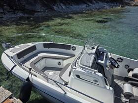 A sleek center console boat docked in crystal-clear waters, showcasing its spacious seating and modern helm — perfect for day trips and coastal exploration.