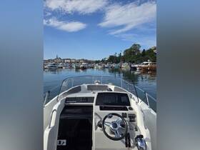 A detailed view of the helm and console of a boat, showcasing the modern controls and equipment, perfect for navigating the waters.