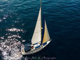 A stunning aerial view of a sailboat gracefully navigating through sparkling blue waters, perfect for showcasing sailing adventures.