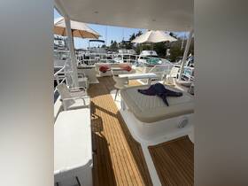 A spacious lounge area on a boat featuring comfortable seating and umbrellas, perfect for relaxing in the shade while enjoying the marina views.