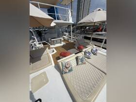 A spacious lounge area on a boat featuring comfortable seating and decorative pillows, perfect for relaxing while enjoying the waterfront views.