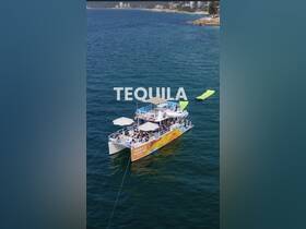 A vibrant party boat named 'Tequila Sunrise' is anchored in clear waters, with guests enjoying the sun and festivities — perfect for a lively day on the water.