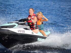 A joyful moment on a jet ski with a woman and a child, capturing the thrill of water sports and family fun under the sun.