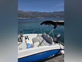 A close-up view of a Cayman boat docked in clear waters, showcasing its sleek design and comfortable seating, perfect for a day out on the water.