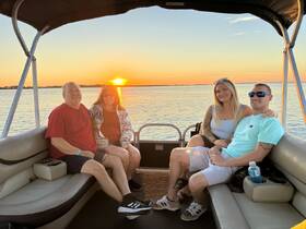 A cheerful group enjoys a sunset cruise on a pontoon boat, capturing the perfect moment of relaxation and celebration on the water.