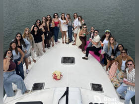 A lively group of friends enjoys a fun celebration aboard a boat, complete with drinks and smiles, perfect for memorable outings on the water.