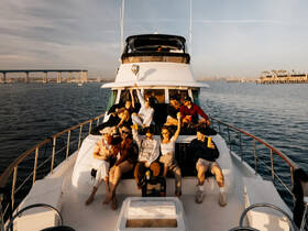 A lively group enjoys drinks on the deck of a yacht, capturing the essence of a perfect sunset cruise with friends.