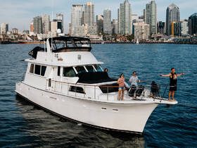 A lively group enjoys a day on a yacht, celebrating against the stunning backdrop of a city skyline — perfect for unforgettable outings on the water.