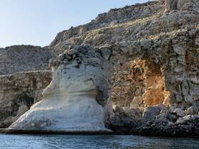 A stunning view of a rocky coastline featuring unique geological formations, perfect for exploring scenic destinations by boat.