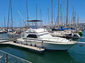 A sleek yacht docked at a bustling marina, surrounded by various sailboats and clear blue skies, perfect for a day on the water.