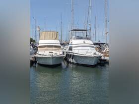 Two yachts docked side by side in a marina, showcasing their sleek designs against a clear blue sky — perfect for boating enthusiasts and charter opportunities.