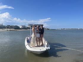 A group of friends poses on a boat, enjoying a sunny day at the beach — perfect for memorable outings and adventures on the water.