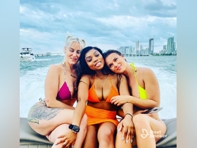 Three friends enjoy a fun day on the water, smiling and posing together on a boat in Miami — perfect for unforgettable summer memories.