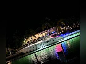 A stunning yacht docked at night, illuminated by colorful lights reflecting on the water — perfect for evening cruises or luxury getaways.