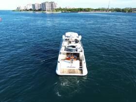 Aerial view of a luxurious yacht named 'Andiamo' docked in serene waters, showcasing its elegant design against a backdrop of coastal buildings.