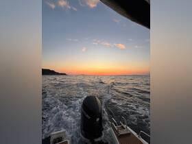 A stunning sunset view from the back of a boat, showcasing the tranquil waters and the silhouette of the coastline — perfect for evening cruises.