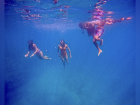 A group of friends enjoys snorkeling underwater, exploring vibrant marine life in crystal-clear waters — a perfect adventure for ocean lovers.
