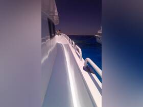 A child enjoys the view from the side of a boat, surrounded by stunning blue waters — a perfect moment for family adventures on the sea.