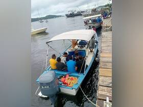 A lively group gathers on a boat at the dock, ready for an adventure on the water — perfect for exploring local destinations.