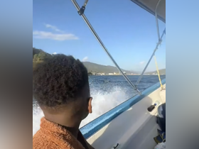A guest enjoys the thrill of a boat ride, taking in the scenic views of the coastline and mountains — a perfect moment for adventure seekers.