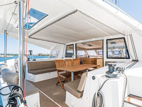 Interior view of a spacious boat cabin featuring comfortable seating and a dining area, perfect for relaxing and enjoying meals while on the water.