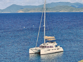 A stunning catamaran anchored in clear blue waters, surrounded by picturesque mountains — perfect for exploring the serene coastline.