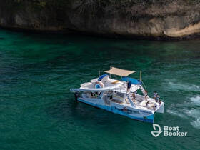 A vibrant boat named 'Margarita' is seen underway in clear turquoise waters, with guests enjoying the scenic ride — perfect for a fun day on the water.