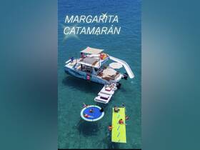 A lively scene featuring guests enjoying water activities around the Margarita catamaran, complete with floating mats and a water slide — perfect for a fun day on the water.