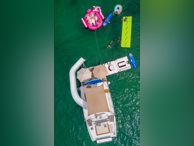 A lively scene featuring a group enjoying a fun day on the water with a slide, floating mats, and paddleboards, showcasing the ultimate boating experience.