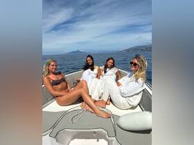 A group of friends relaxes on the deck of a boat, enjoying the sun and sea — perfect for a day of fun and celebration on the water.