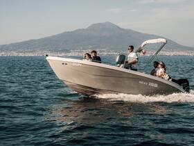 A lively group enjoys a boat ride on the water with Mount Vesuvius in the background, capturing the essence of adventure and scenic beauty.